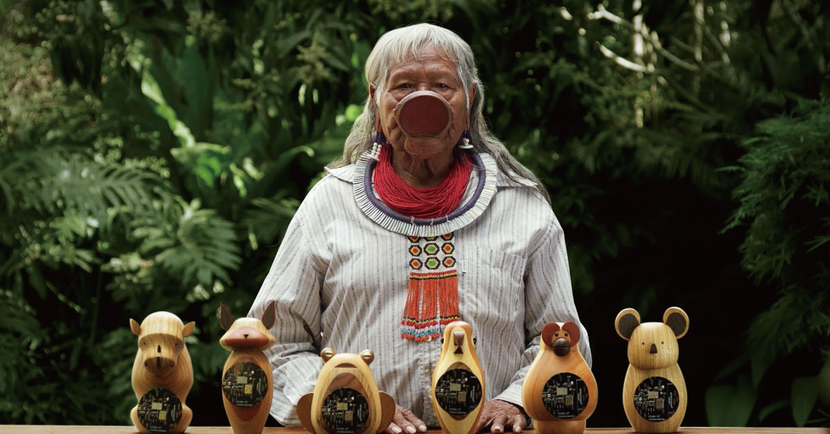 巴西原住民領袖Raoni Metuktire，與含有良心之碼的芯片的木雕刻品。